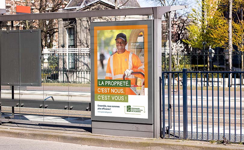 Affiche grand format dans un abri bus présentant un agent d'entretien pour la campagne propreté réalisée par le Communauté d'Agglomération de l'Albigeois